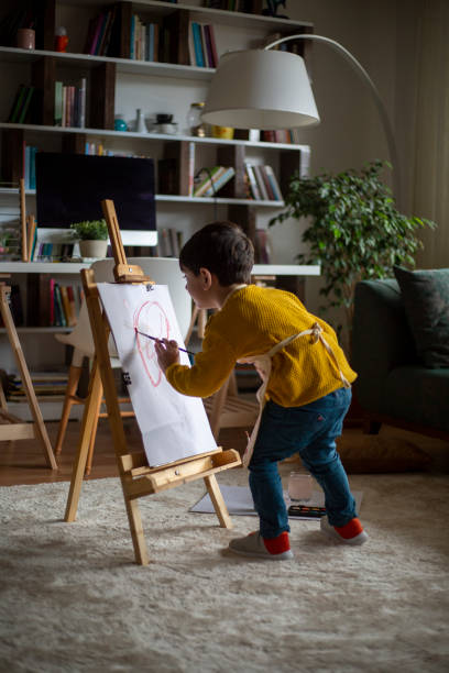 счастливый мал�енький художник ребенка рисунок с красочными красками в домашних условиях - baby toddler child flower стоковые фото и изображения