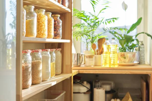 kitchen utensils, sunflower oil on wooden table in pantry, food storage at home - cooking process imagens e fotografias de stock