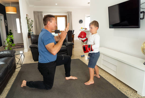 istock COVID-19 Shutdown. Father and son having fun boxing together and staying physically active at home during coronavirus quarantine. Stay home, Exercise, Health Self-care for Coronavirus isolation. 1215599121