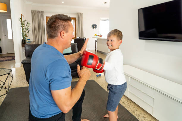istock COVID-19 Shutdown. Father and son having fun boxing together and staying physically active at home during coronavirus quarantine. Stay home, Exercise, Health Self-care for Coronavirus isolation. 1215600331