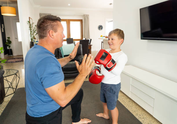 istock COVID-19 Shutdown. Father and son having fun boxing together and staying physically active at home during coronavirus quarantine. Stay home, Exercise, Health Self-care for Coronavirus isolation. 1215600332