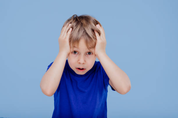 istock surprised little boy with hands on head looks at camera 1215600969