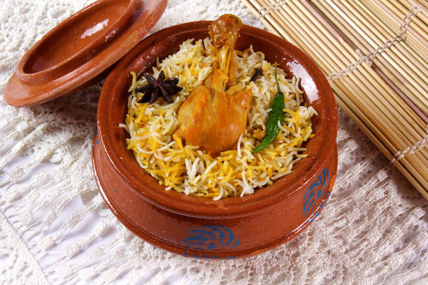 Delicious spicy chicken biryani in traditional bowl on White background, Indian or Pakistani famous masala rice food. Potato and meat are main ingredients of this recipe | Best Ramadan iftar meal.