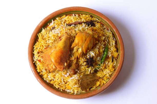 Delicious spicy chicken biryani in traditional bowl on White background, Indian or Pakistani famous masala rice food. Potato and meat are main ingredients of this recipe | Best Ramadan iftar meal.