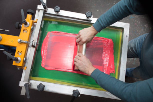 istock Silk screen printing. Serigraphy. Color paints and fabric. Plastisol paint and squeegee. 1215606023