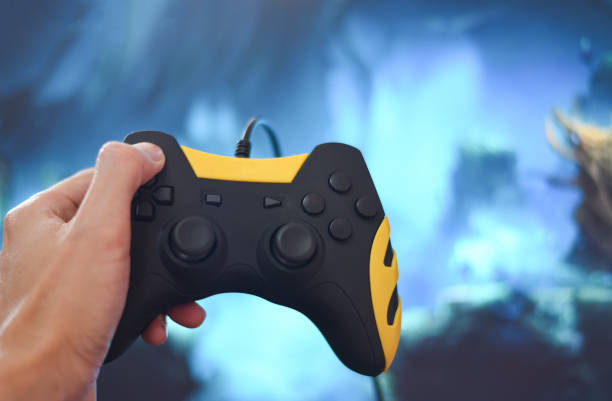 istock Gamer and guy controller with game pad joystick on hand playing gaming and watching video on tv or Computer games console - The boy holding hobby playful enjoyment fun and entertainment 1215611353