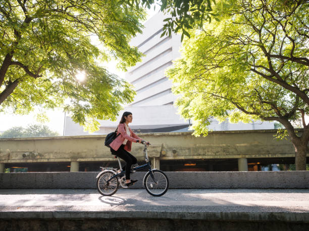 jovenva va a trabajar en bicicleta - vehículo de transporte de gente fotografías e imágenes de stock