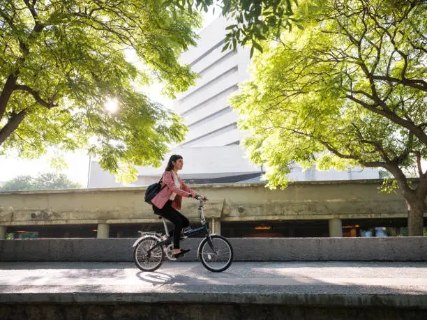 A young mexican woman riding her bike in the city and going to work.