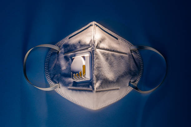 N95 mask on white table with dramatic contrasty blue tone lighting, health concept