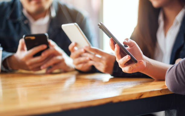 istock Group of people using and looking at mobile phone together 1215623813