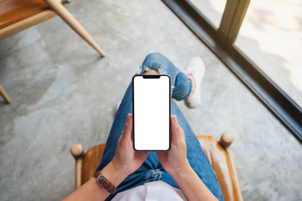 istock a woman holding mobile phone with blank white screen while sitting in office 1215623854