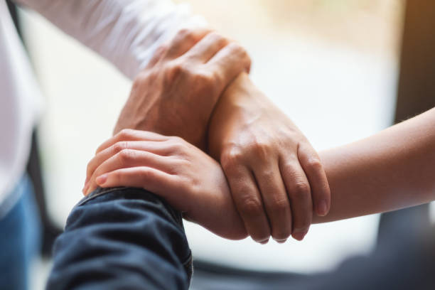 istock People putting their hands in a circle together for unity and teamwork 1215623965
