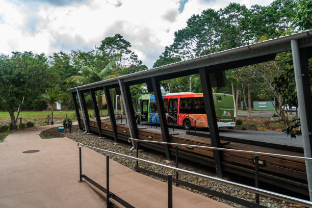 Shuttle bus serving tourists is reflected from the glass windows of Mossman Gorge Centre in Queensland, Australia.