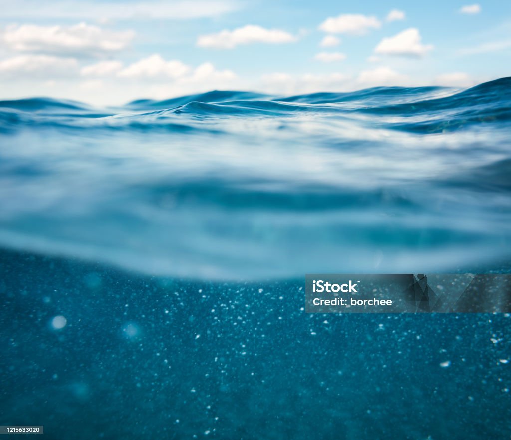 Undersea View Sea waves with idyllic blue sky (combined underwater and surface view). Sea Stock Photo