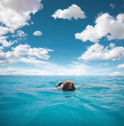 Young woman floating on a beautiful turquoise sea (Kefalonia, Greece).