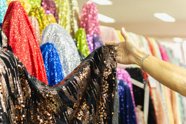 istock Hand pick a roll of Sequin fabric cloth in fabric store. 1215633241