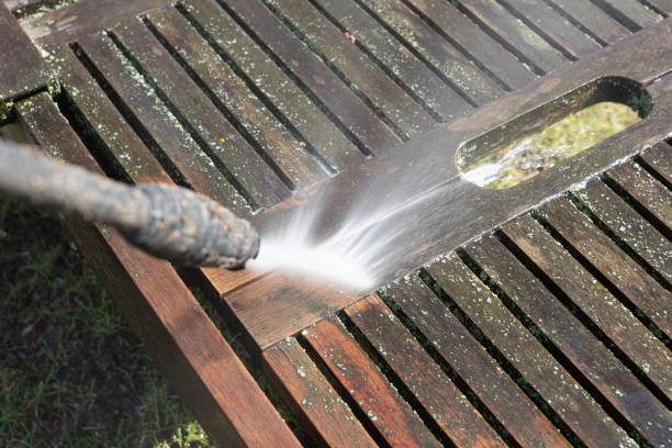 Cleaning a wooden sunbed with a high-pressure cleaner stock photo