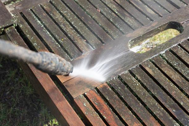 Cleaning a wooden sunbed with a high-pressure cleaner Cleaning a wooden sunbed with a high-pressure cleaner in the garden on a meadow showing the difference of the surface before and after cleaning wet wood texture stock pictures, royalty-free photos & images