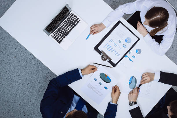 istock Group of business people analyzing financial documents, view from above. Business team at meeting 1215638116