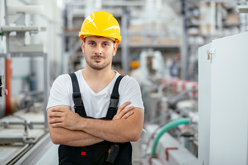 Manual worker in factory. Inspector. Factory. Engineer. Quality control. Manufacturing. Production. Wearing protective clothes. Serious. Tablet