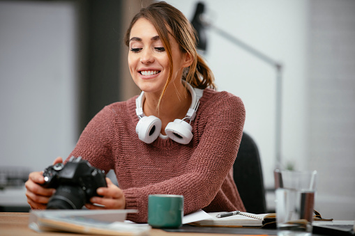 Young woman in office with camera