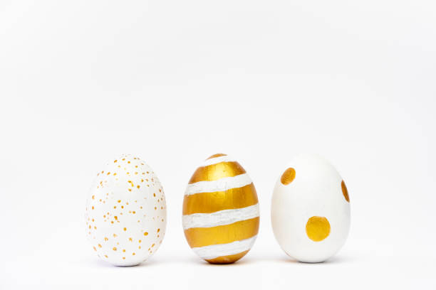 istock Three easter trendy golden decorated eggs on white background. Happy Easter card with copy space for text Minimal easter style 1215641678