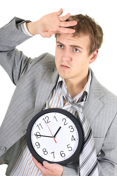 istock Tired businessman in grey suit holding a clock 121564744