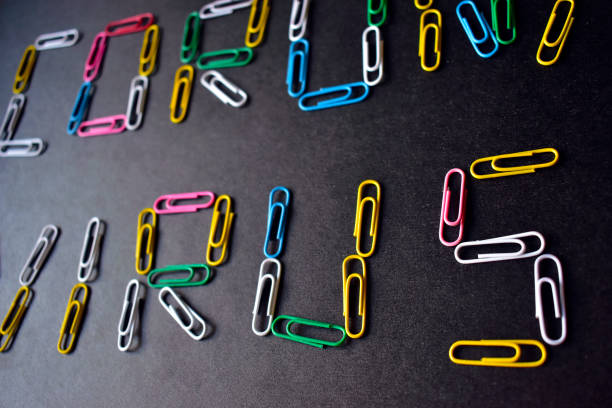 istock Coronavirus with colored paper clips on a black background 1215650011