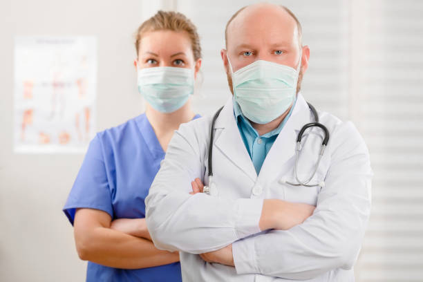 médico confiante e exausto e enfermeira com braços cruzados em hostpital - hostpital - fotografias e filmes do acervo