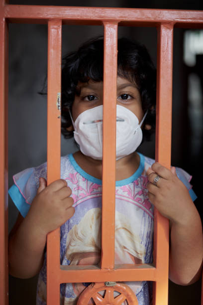 istock Bored Little girl wearing protective mask during home quarantine 1215650691