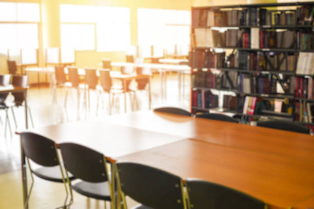 istock Library books with table - Blurred Image many books on bookshelf in library room 1215651701
