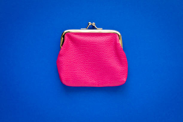 istock Fashionable pink wallet on a blue background. Close up. 1215654735