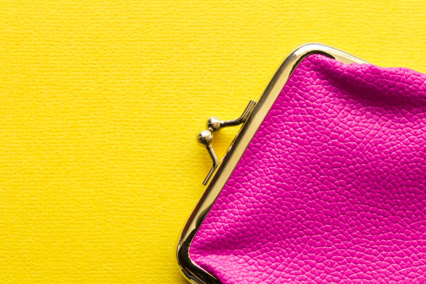 istock Fashionable pink wallet on a yellow background. Close up. 1215655152