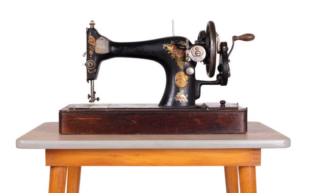 istock Antique, vintage sewing machine on an old table, isolated on white 1215655195