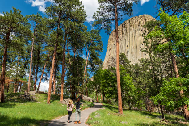 Two hikers looking at Devil Towers, United States