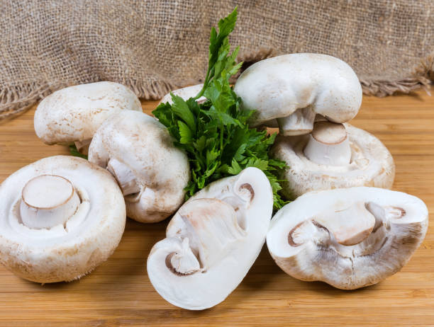 istock Fresh uncooked button mushrooms and parsley on the wooden surface 1215661069