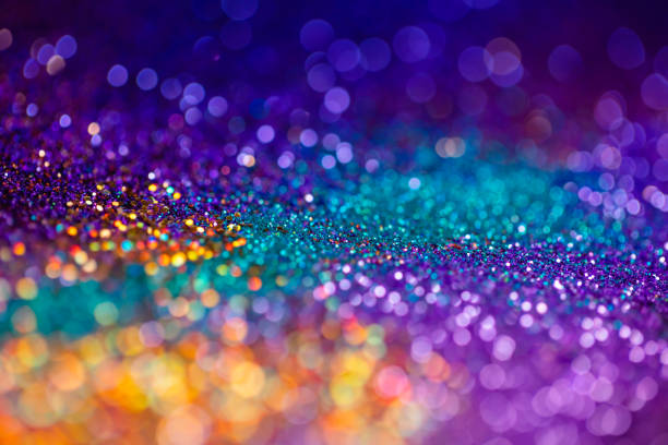 Festive twinkle glitters background, abstract sparkle backdrop with circles,modern design overlay with sparkling glimmers. Yellow, blue, purple and green backdrop glittering sparks with glow effect.