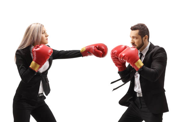 homme d’affaires et femme d’affaires se battant avec des gants de boxe - women business strength boxing photos et images de collection