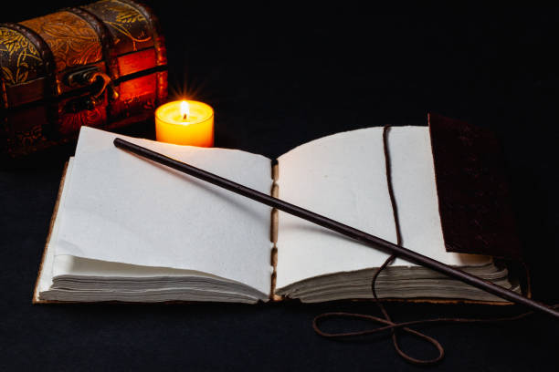 istock Image of open magic book and wand 1215668702