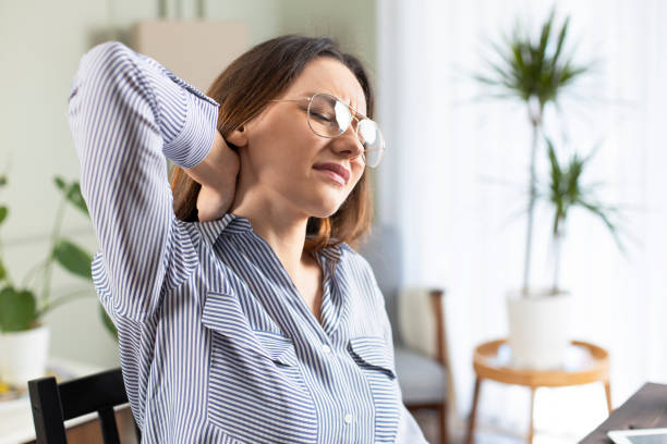 istock Freelancer young woman suffering with neck pain 1215668753