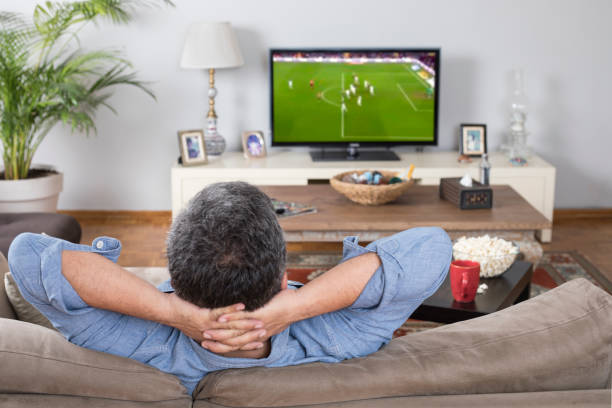 hombre viendo partido de fútbol en casa - espacio masculino fotografías e imágenes de stock