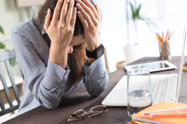istock Freelancer young woman holding head in hands 1215669260
