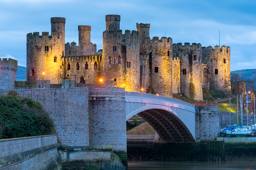 Conwy Castle illuminated at dusk in Conwy, North Wales, UK