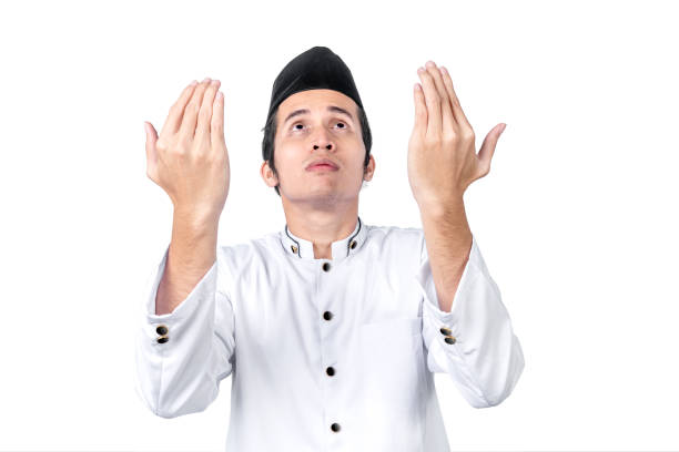 istock Asian Muslim man standing while raised hands and praying 1215669474