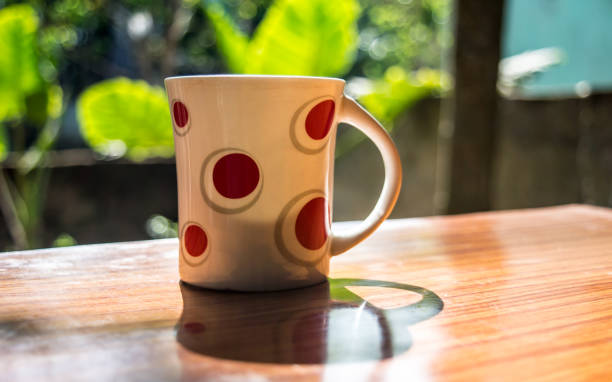 istock Coffee Cup backlit by Morning Sunlight. Dining Table top shot. 1215669792