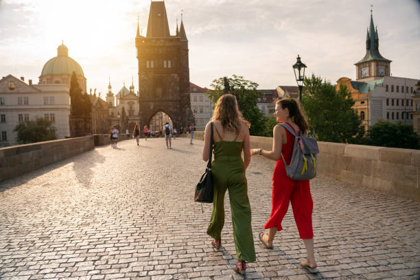 Female friends on holiday walking on Charles Bridge in Prague stock photo
