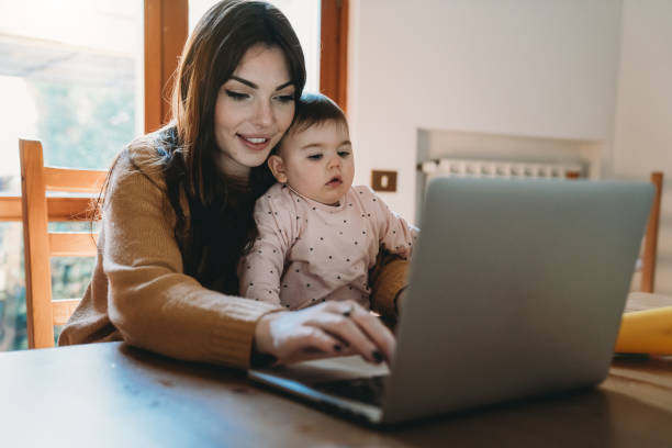 istock A young mother is working at home using computer while she's taking care of her daughter 1215672440
