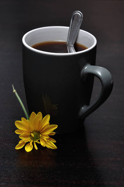 istock A gray mug filled with black coffee and a yellow aster 1215672990