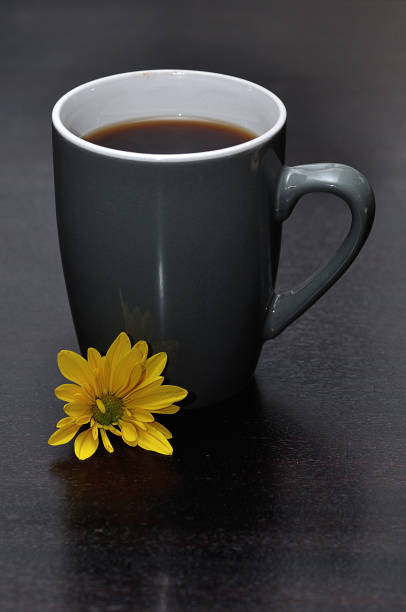istock A gray mug filled with black coffee and a yellow aster 1215673618