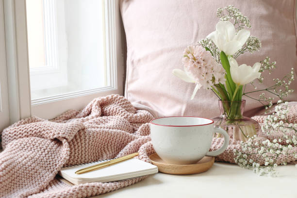 Cozy Easter, spring still life scene. Cup of coffee, notebook, golden pen, pink knitted plaid near window. Vintage feminine styled photo. Floral composition with tulips, hyacinth and Gypsophila flowers. Cozy Easter, spring still life scene. Cup of coffee, notebook, golden pen, pink knitted plaid near window. Vintage feminine styled photo, floral composition with tulips, hyacinth and Gypsophila flowers. pink tea stock pictures, royalty-free photos & images